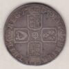 1707 E silver shilling coin featuring the draped bust of Queen Anne on the Obverse. The crowned cruciform shield on the Reverse.