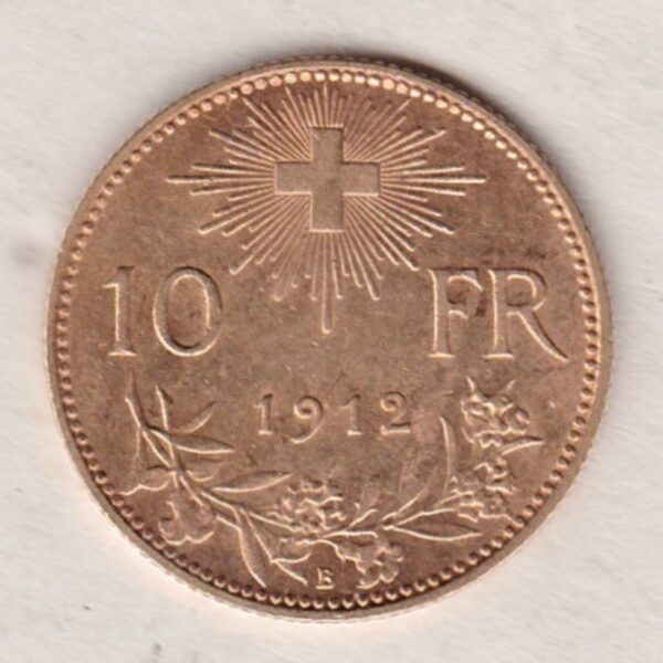 1912 B Switzerland Gold Ten Francs coin features a female figure on the obverse. The Swiss shield surrounded by oak leaves on the Reverse.