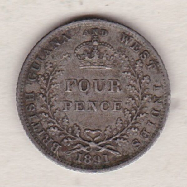 1891 British Guiana Fourpence Coin. The obverse features Queen Victoria. The reverse features the crowned denomination within a wreath.