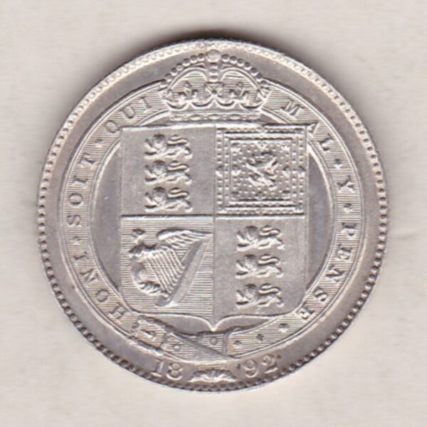 1892 Silver Shilling coin featuring Queen Victoria on the Obverse. The Reverse features the crowned Royal shield within Garter, with divided date below.