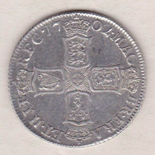 1702 silver shilling coin featuring the draped bust of Queen Anne. The crowned cruciform shields with central Garter star on the Reverse.