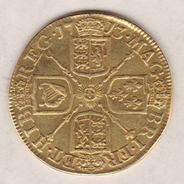 1713 Gold Guinea Coin featuring the portrait of Queen Anne on the obverse. The crowned cruciform shields around central Garter star on the reverse.