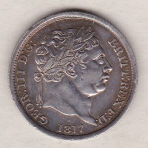 1817 silver shilling coin featuring King George III on the Obverse. The Reverse features an ornate crowned Royal shield overlaid with another shield.