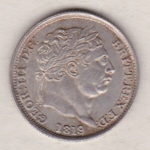 1819 silver shilling coin featuring King George III on the Obverse. The Reverse features an ornate crowned Royal shield overlaid with another shield.