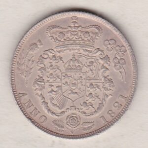 1821 silver shilling coin featuring King George IV on the Obverse. The Reverse has the crowned and garnished shield of arms with national flower emblems.