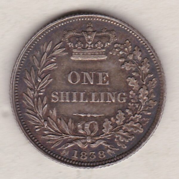 1838 silver shilling coin featuring Queen Victoria young head on the Obverse. The Reverse has a crown, laurel and oak leaves within an open wreath.