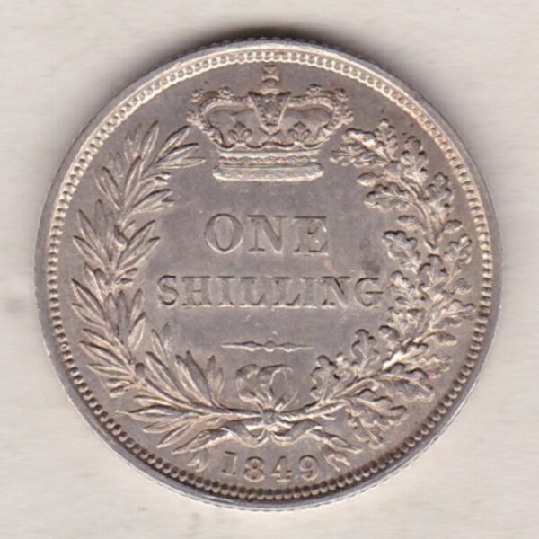 1849 silver shilling coin featuring Queen Victoria young head on the Obverse. The Reverse has a crown, laurel and oak leaves within an open wreath.