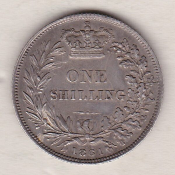 1861 silver shilling coin featuring Queen Victoria young head on the Obverse. The Reverse has a crown, laurel and oak leaves within an open wreath.