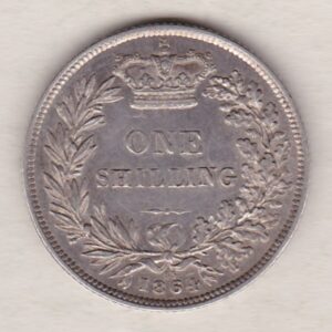 1864 silver shilling coin featuring Queen Victoria young head on the Obverse. The Reverse has a crown, laurel and oak leaves within an open wreath.