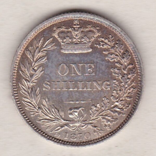 1870 silver shilling coin featuring Queen Victoria young head on the Obverse. The Reverse has a crown, laurel and oak leaves within an open wreath.