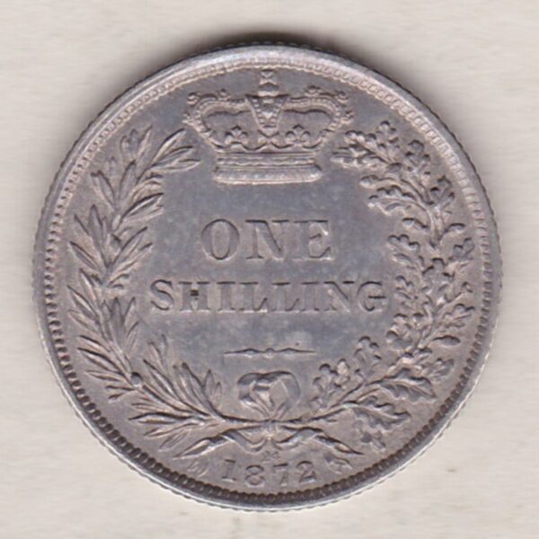 1872 silver shilling coin featuring Queen Victoria young head on the Obverse. The Reverse has a crown, laurel and oak leaves within an open wreath.