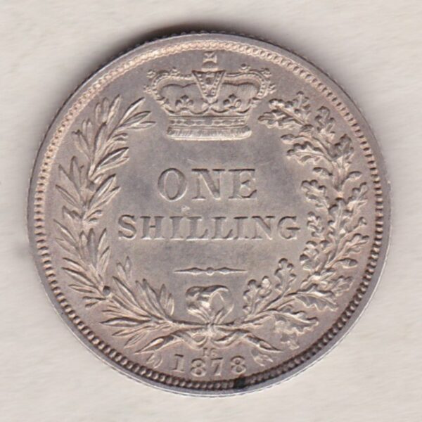 1878 silver shilling coin featuring Queen Victoria young head on the Obverse. The Reverse has a crown, laurel and oak leaves within an open wreath.