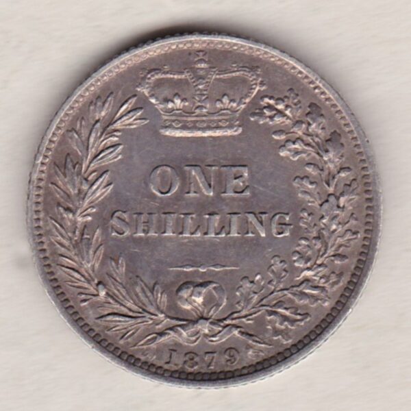 1879 silver shilling coin featuring Queen Victoria young head on the Obverse. The Reverse has a crown, laurel and oak leaves within an open wreath.