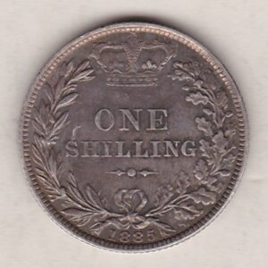 1885 silver shilling coin featuring Queen Victoria young head on the Obverse. The Reverse has a crown, laurel and oak leaves within an open wreath.