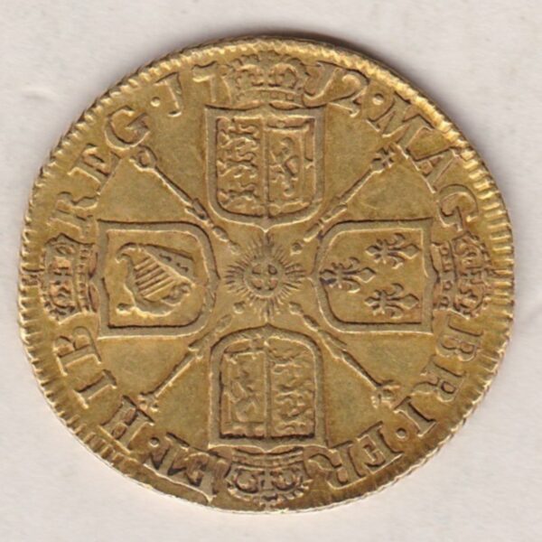 1712 Gold Guinea Coin featuring the portrait of Queen Anne on the obverse. The crowned cruciform shields around central Garter star on the reverse.