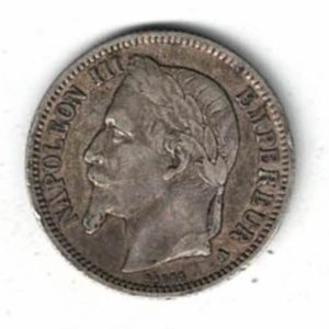 1869 A France Silver One Franc Coin. The obverse features the bust of Napoleon III facing left. The reverse features a shield decorated with an eagle.