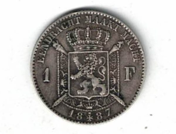 1887 Belgium Silver One Franc Coin. The obverse features Leopold II facing left. The reverse features Crowned arms on ornate shield divide denomination.