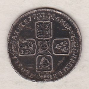 1746 Lima silver sixpence coin featuring a laureate bust of George II. There are four crowned shields arranged in a cross on the Reverse.
