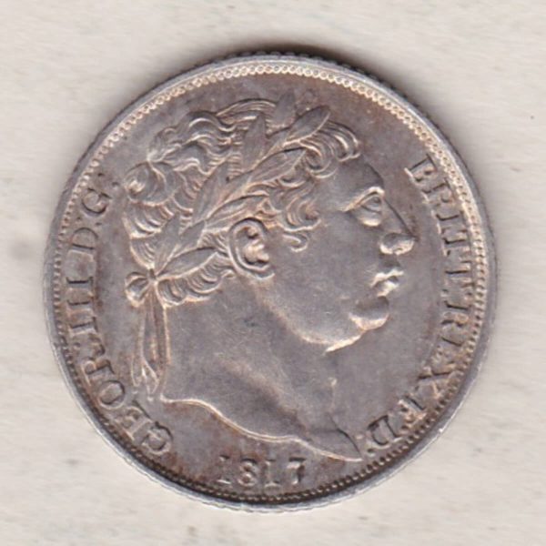 1817 silver sixpence coin featuring King George III on the Obverse. The Reverse features a crowned quartered shield of arms.