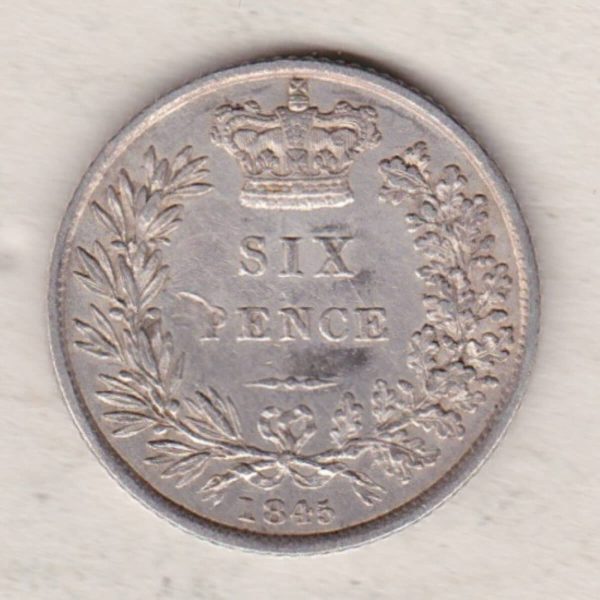 1845 silver sixpence coin featuring young head Queen Victoria on the Obverse. The crowned denomination within a wreath and date below on the Reverse.