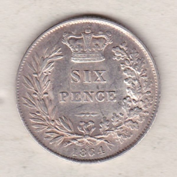 1864 silver sixpence coin featuring young head Queen Victoria on the Obverse. The crowned denomination within a wreath and date below on the Reverse.