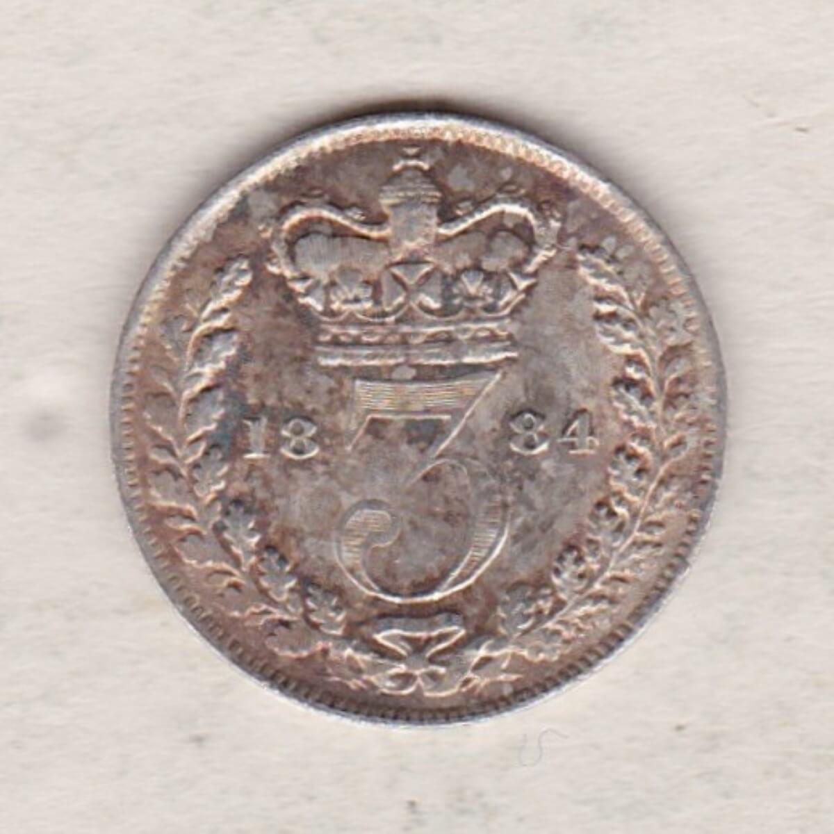 1884 Silver Threepence coin featuring the portrait of Queen Victoria on the Obverse. The Reverse features a crowned denomination dividing the date.