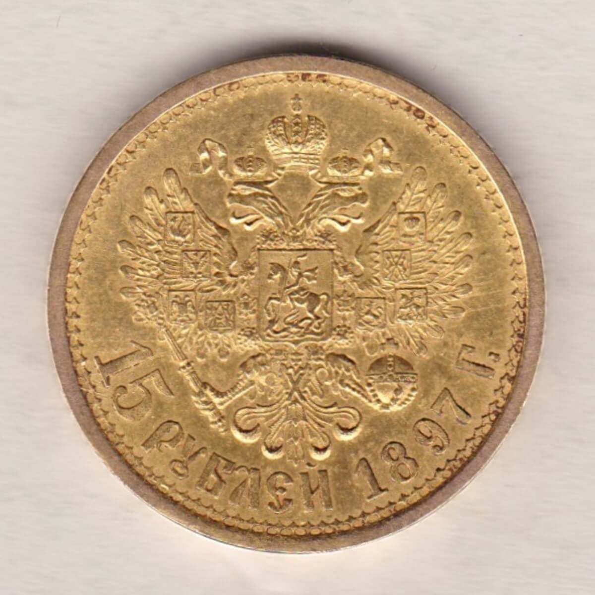 1897 Gold Russia Fifteen Roubles coin. The obverse features Emperor Nicholas II. The reverse features the two-headed eagle with date and denomination.