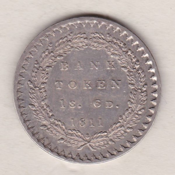 1811 Silver One Shilling And Sixpence Bank Token emergency issue bank token. The token features the laureate portrait of King George III on the obverse.