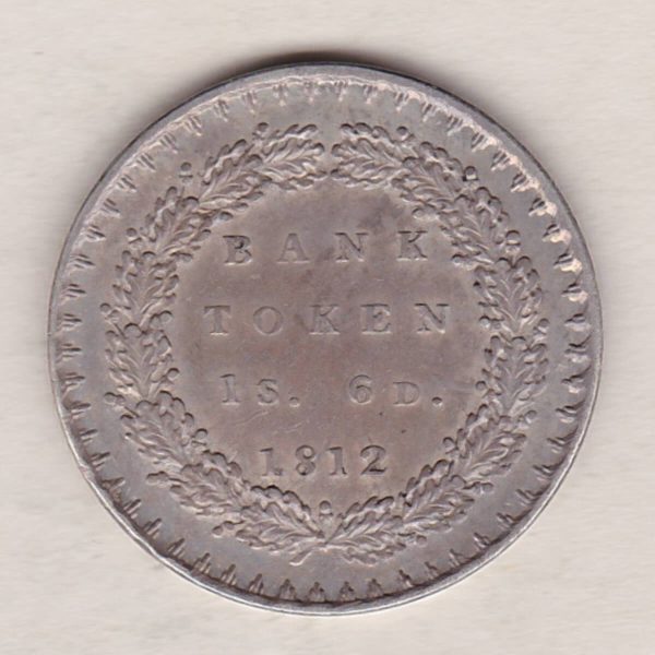 1812 Silver One Shilling And Sixpence Bank Token emergency issue bank token. The token features the laureate portrait of King George III on the obverse.