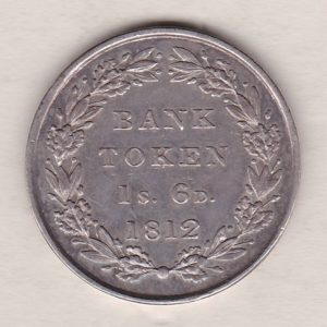 1812 Silver One Shilling And Sixpence emergency issue bank token. The token features the laureate portrait of King George III on the obverse.