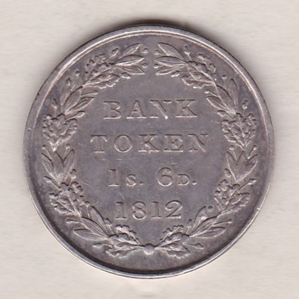 1812 Silver One Shilling And Sixpence emergency issue bank token. The token features the laureate portrait of King George III on the obverse.
