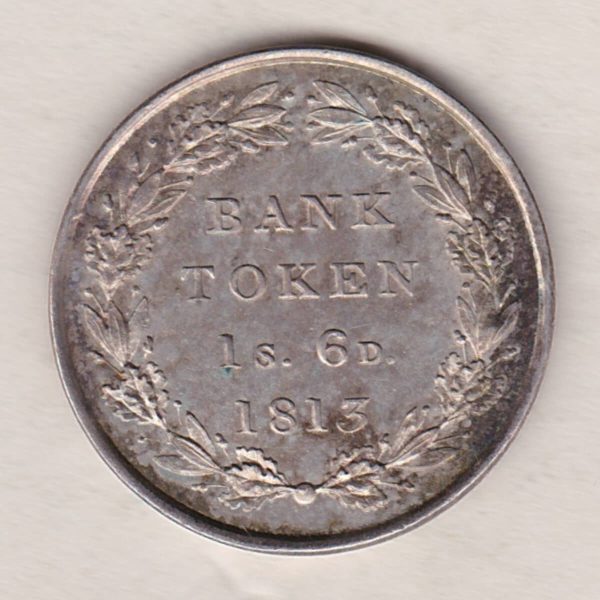 1813 Silver One Shilling And Sixpence emergency issue bank token. The token features the laureate portrait of King George III on the obverse.