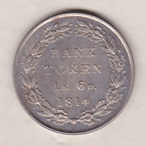 1814 Silver One Shilling And Sixpence emergency issue bank token. The token features the laureate portrait of King George III on the obverse.