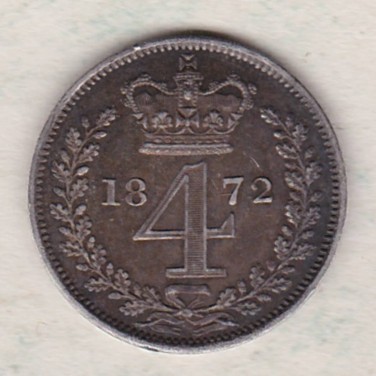 1872 silver maundy fourpence coin featuring Queen Victoria on the Obverse. The crowned denomination dividing date within an oak wreath on the Reverse.