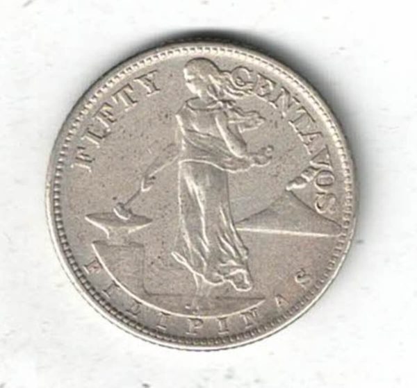 1944 S Philippines Silver Fifty Centavos Coin. The obverse features a standing lady holding a hammer with volcano on the right.