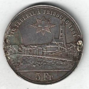 Ex Mount 1881 Switzerland Silver Five Francs Coin. The obverse features arms with city views and denomination. The reverse features three figures.