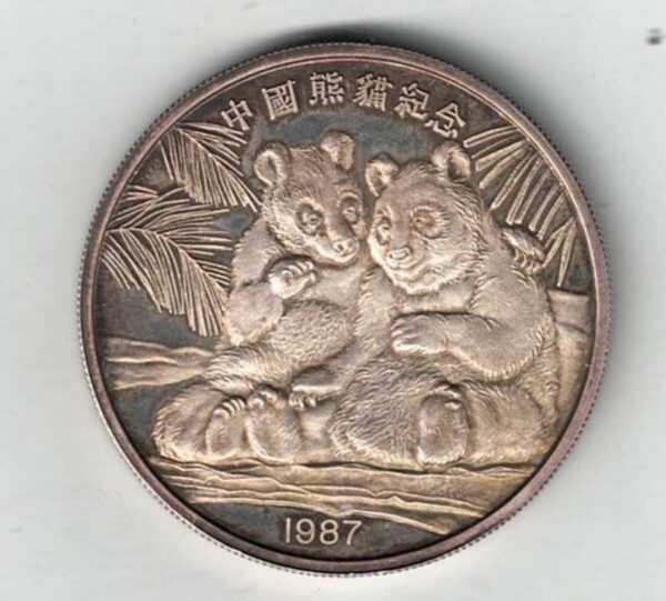 Boxed 1987 China Silver Two Ounce Pandas Round. The obverse features two pandas hugging under a palm tree. The reverse features the back of the pandas.