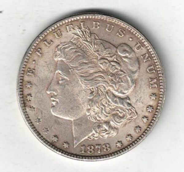 1878 Silver USA Morgan Dollar coin featuring lady liberty on the obverse. The eagle holding arrows and an olive branch on the reverse.