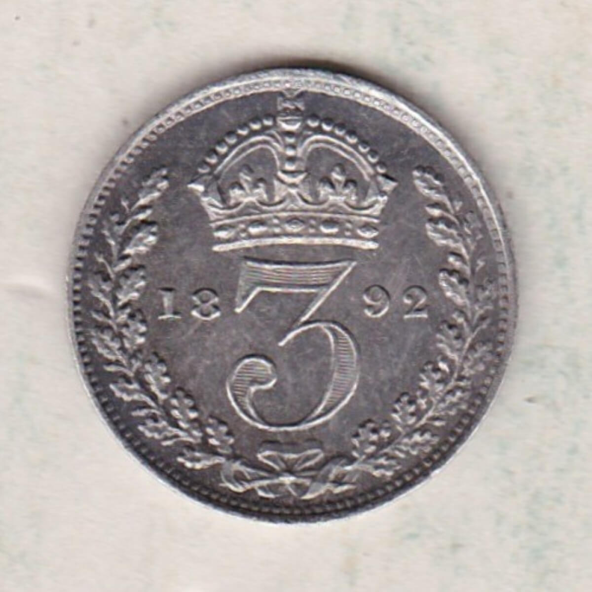 1892 Silver Maundy Threepence coin featuring Queen Victoria on the obverse. The reverse features a crowned denomination dividing date within an oak wreath.