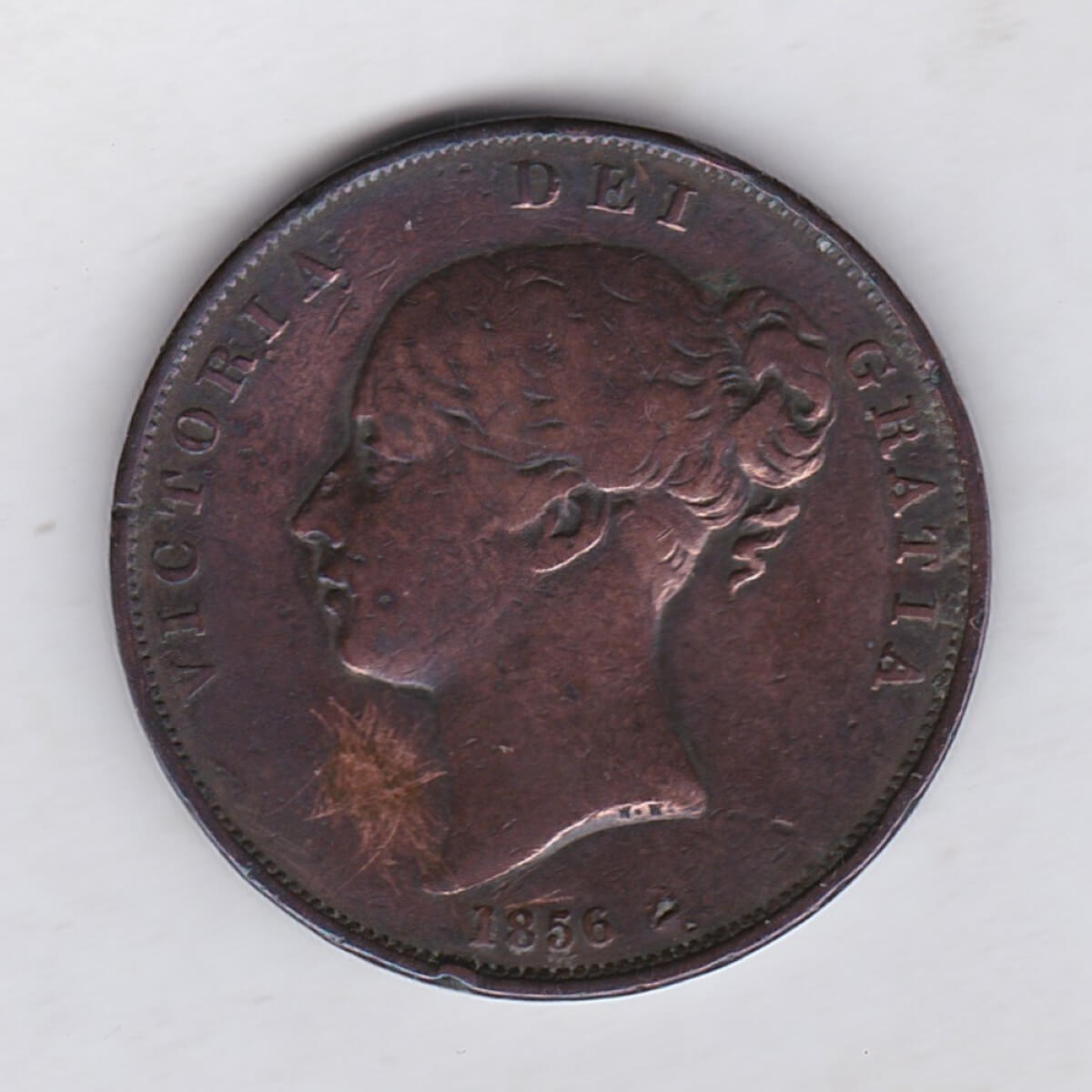 1856 copper penny coin featuring the young head portrait of Queen Victoria on the Obverse. The coin depicts Britannia seated to the right on the Reverse.