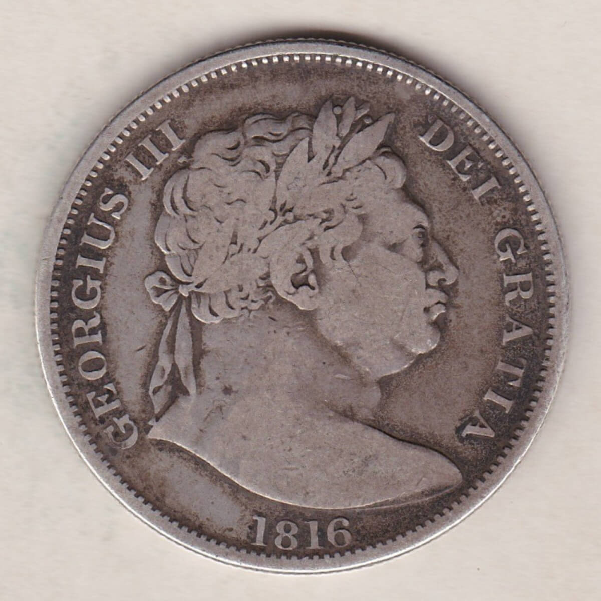 1816 Silver Halfcrown coin with King George III on the Obverse. The reverse features a a crowned Garter and ornate Royal shield of arms.