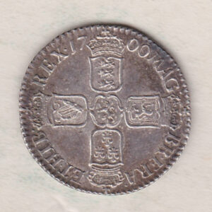 1700 silver shilling coin featuring the laureate or draped bust of William III on the Obverse. The crowned cruciform shields on the Reverse.