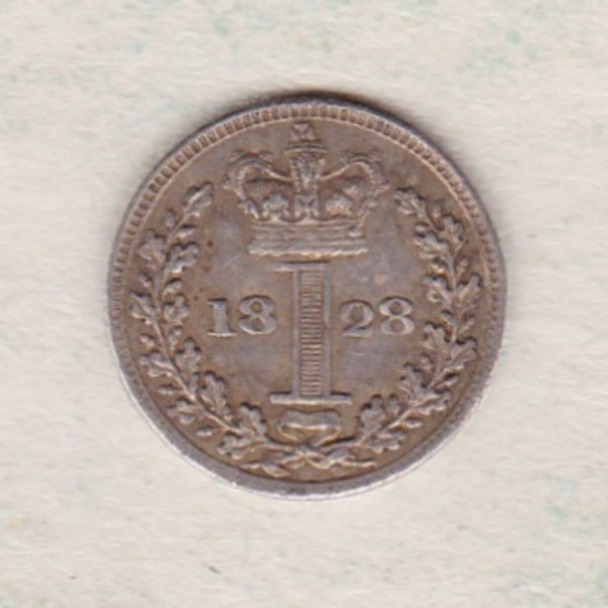 1828 Silver Maundy Penny coin featuring King George IV on the obverse. A central crowned denomination above the date on the reverse.
