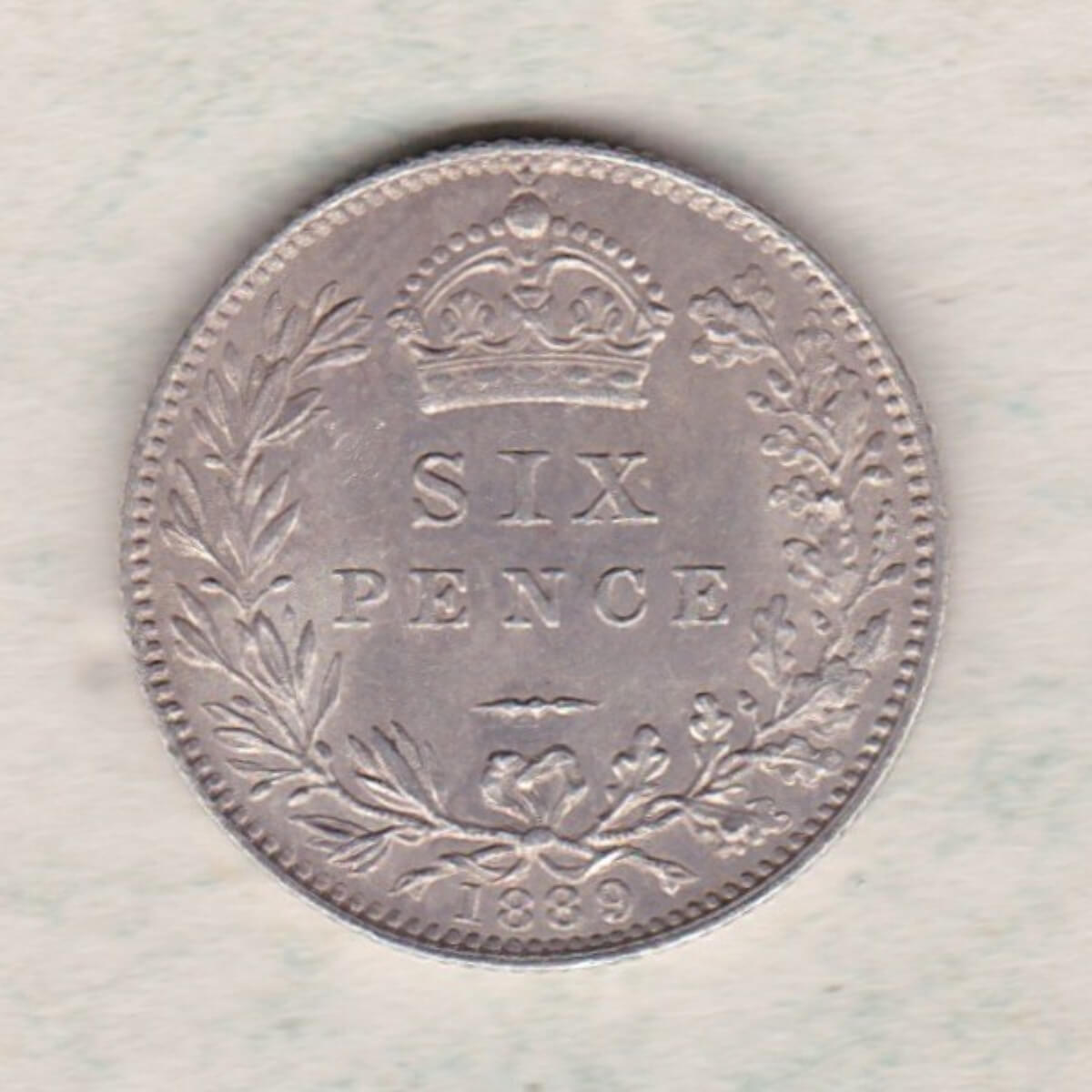 1889 Silver Sixpence coin featuring Queen Victoria on the Obverse. The Reverse features a crowned denomination within wreath.