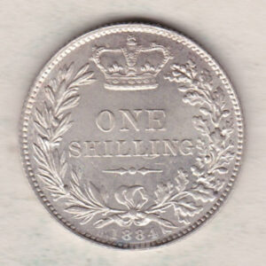 1884 silver shilling coin featuring Queen Victoria young head on the Obverse. The Reverse has a crown, laurel and oak leaves within an open wreath.