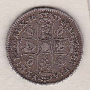 1677 Silver Halfcrown coin. The obverse features King Charles II. The reverse features the crowned cruciform shields around central Garter star.
