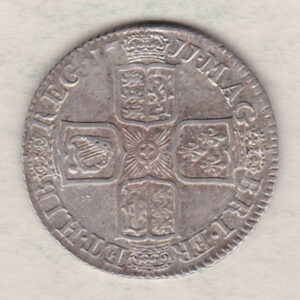 1711 silver shilling coin featuring the draped bust of Queen Anne. The crowned cruciform shields with central Garter star on the Reverse.