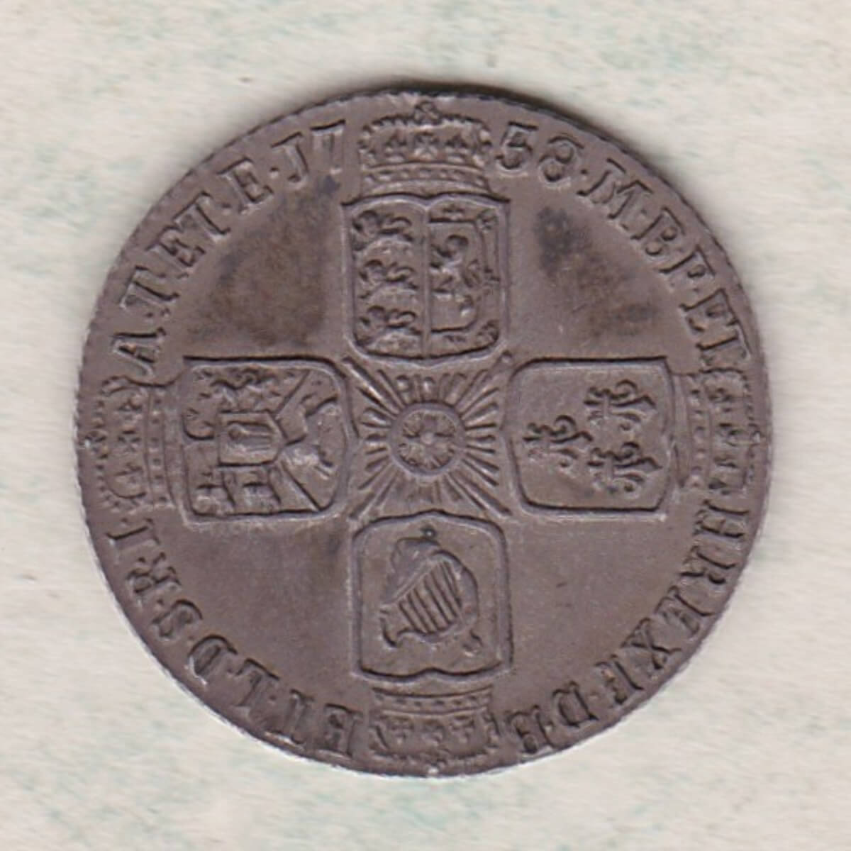 1758 silver sixpence coin featuring a laureate bust of George II. There are four crowned shields arranged in a cross on the Reverse.