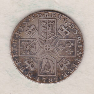 1787 silver shilling coin featuring a laureate and draped bust of George III. The cruciform shields, this coin has no hearts on the Reverse.