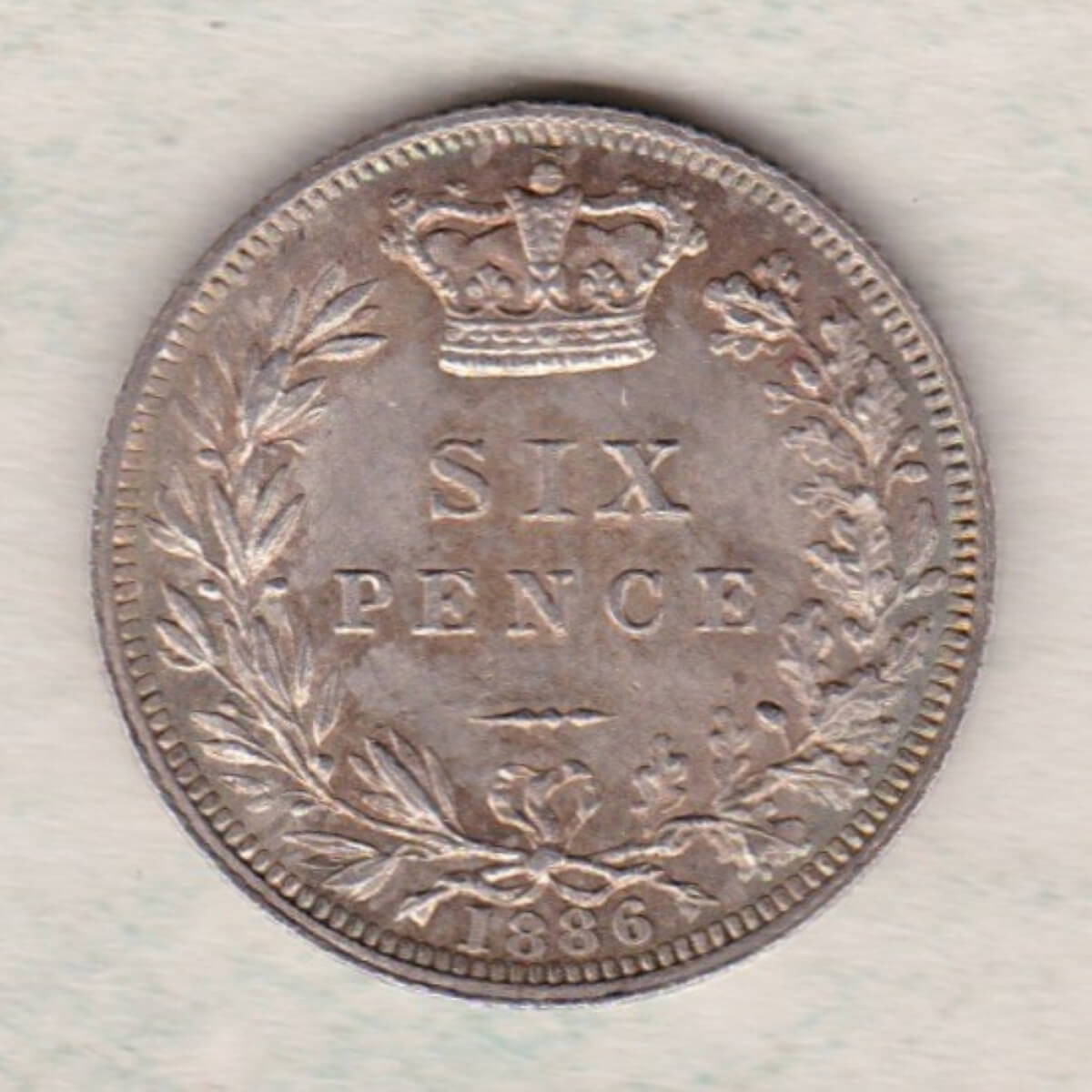 1886 Silver Sixpence coin featuring Queen Victoria on the Obverse. The Reverse features a crowned denomination within wreath.